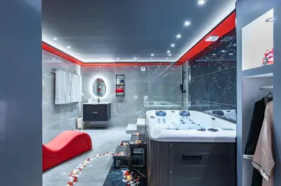 a bathroom with a tub and a sink and a red bench at Secret Night Pamiers in Pamiers