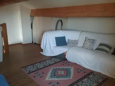 a bedroom with a couch in a room with a rug at Appt vue imprenable sur la mer in Gruissan