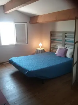 a bedroom with a large bed with a blue bedspread at Appt vue imprenable sur la mer in Gruissan