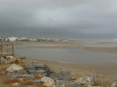a large body of water with rocks on the beach at Appt vue imprenable sur la mer in Gruissan