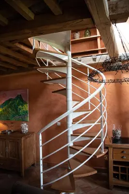 a spiral staircase in a room with a wooden ceiling at Pure Canigou House An Authentic and Charming Town house with 3 bedrooms in Montalba-le-Château