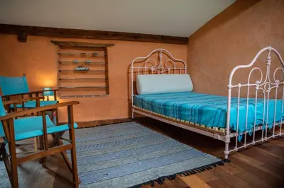 a bedroom with two beds and a table and chairs at Pure Canigou House An Authentic and Charming Town house with 3 bedrooms in Montalba-le-Château