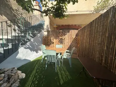 a dining room with a table and chairs and windows at Les Loriots in La Redorte