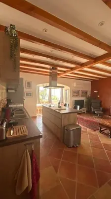 a kitchen and living room with a couch and a table at Les Loriots in La Redorte
