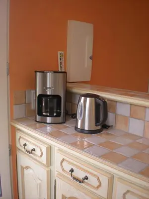 a kitchen counter with a microwave and a coffee maker at Gites De La Grasse in Carcassonne