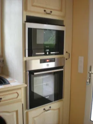a kitchen with a microwave and a television in a cabinet at Gites De La Grasse in Carcassonne