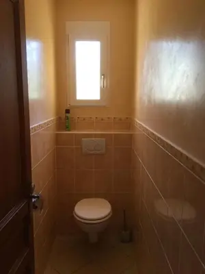 a bathroom with a toilet and a window at Gites De La Grasse in Carcassonne