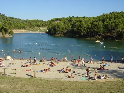 a group of people on the beach at a lake at Gites De La Grasse in Carcassonne