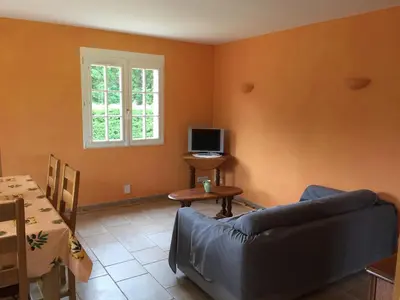 a living room with a couch and a television at Gites De La Grasse in Carcassonne