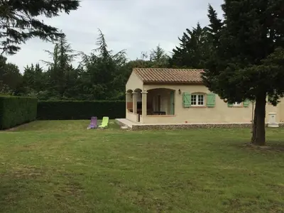 a small house with two chairs in a yard at Gites De La Grasse in Carcassonne