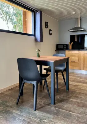 a kitchen with red chairs and a table in it at Les gîtes du Canal du midi - Gîte Bois & Cailloux in Montgaillard-Lauragais