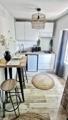 a kitchen with white cabinets and a table at N3-Barbacane-Pieds Cité-Clim mobile in Carcassonne