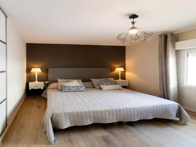 a bedroom with a large white bed with two lamps at Magnificent villa with private pool in Narbonne