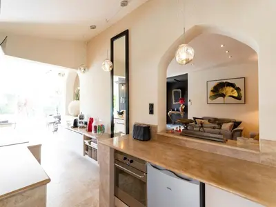 a kitchen with a counter and a living room at Magnificent villa with private pool in Narbonne