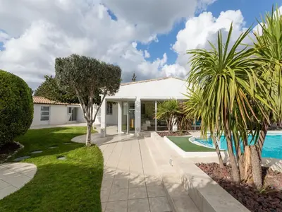 a house with a swimming pool and palm trees at Magnificent villa with private pool in Narbonne