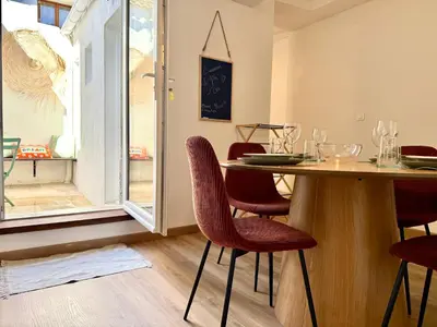 a dining room with a table and chairs and a window at Le Gîte d'Oré - 2 Chambres et Climatisation in Carcassonne