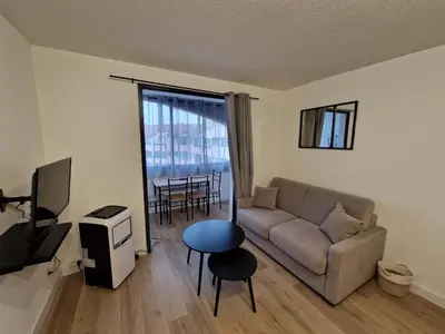 a living room with a couch and a tv and a table at La Porte de la Mer in Port-la-Nouvelle