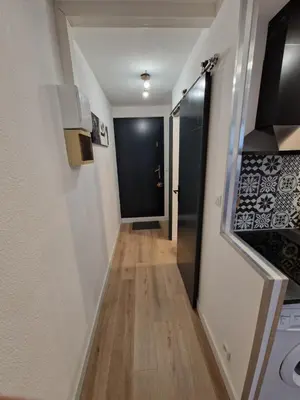 a hallway leading to a door in a room at La Porte de la Mer in Port-la-Nouvelle