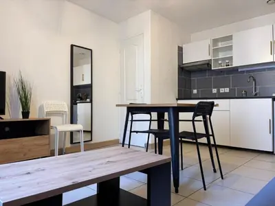 a kitchen and dining room with a table and chairs at T2 contemporain centre ville in Narbonne