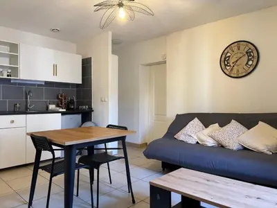 a living room with a couch and a table and a clock at T2 contemporain centre ville in Narbonne