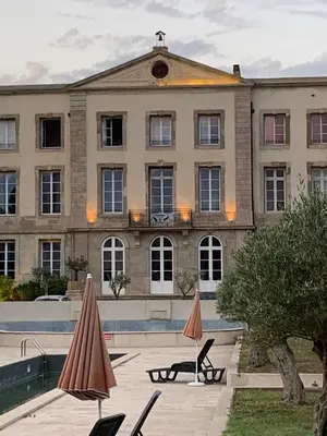 a large building with two umbrellas in front of it at La Redorte 4 in La Redorte