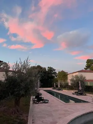 a swimming pool with benches and a cloudy sky at La Redorte 4 in La Redorte