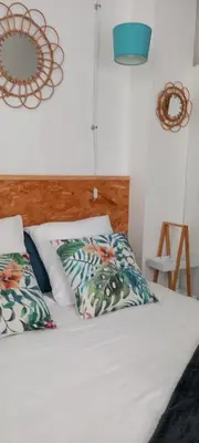 a bed with two pillows and a mirror on the wall at One Hundred in Carcassonne