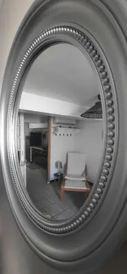 a mirror with a chair in a living room at One Hundred in Carcassonne