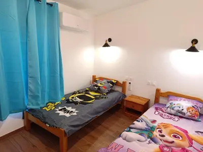 a bedroom with two twin beds and blue curtains at Château de Prax Viel - piscine et mini ferme, climatisé in Lagrasse
