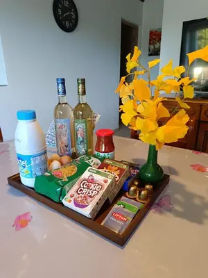 a tray with food and drinks and a vase with flowers at Château de Prax Viel - piscine et mini ferme, climatisé in Lagrasse