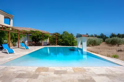 a swimming pool with blue chairs and a house at Domaine Des Lucques B&B with Private Infinity Pool & Grand Olive Grove in Bize-Minervois