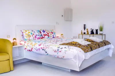 a bedroom with a bed and a yellow chair at Domaine Des Lucques B&B with Private Infinity Pool & Grand Olive Grove in Bize-Minervois