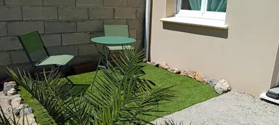 a small garden with chairs and a table and grass at Chez Jacques in Port-la-Nouvelle