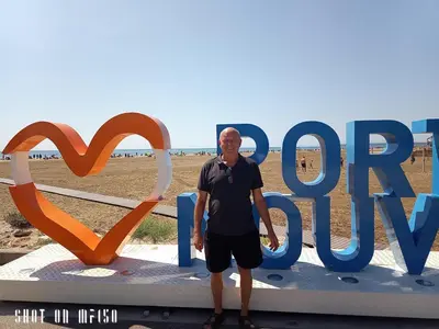 a man standing in front of a sign at the beach at Chez Jacques in Port-la-Nouvelle