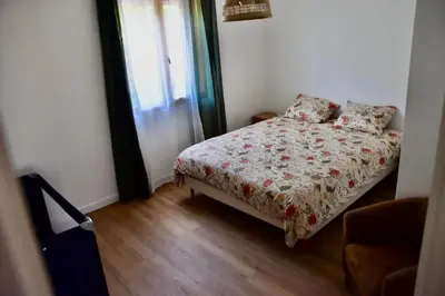 a bedroom with a bed with a floral comforter at Villa avec piscine chauffée et jacuzzi in Ouveillan