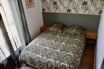 a bedroom with a bed with a flowered comforter at Villa avec piscine chauffée et jacuzzi in Ouveillan