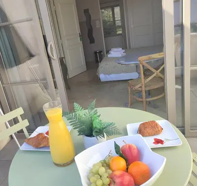 a table with a bowl of fruit and a glass of orange juice at LA REDORTE Studio 15 in La Redorte