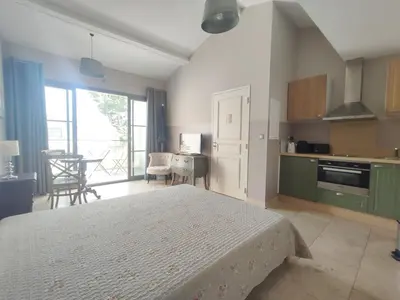 a bedroom with a bed and a kitchen with a table at LA REDORTE Studio 15 in La Redorte