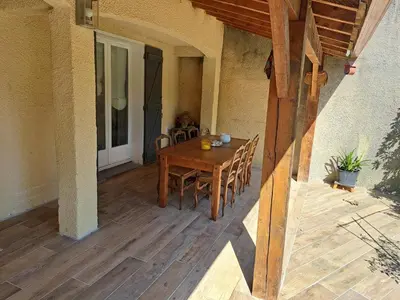 a wooden table and chairs on a patio at Villa avec piscine à Montolieu in Montolieu