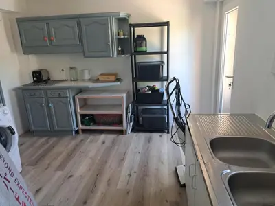 a kitchen with green cabinets and a wooden floor at Villa avec piscine à Montolieu in Montolieu