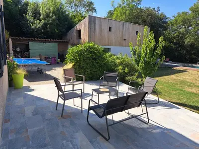 a group of chairs and tables on a patio at Villa avec piscine à Montolieu in Montolieu