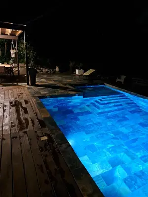a swimming pool at night with blue lighting at Villa avec piscine à Montolieu in Montolieu