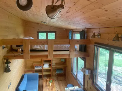 a bedroom in a tree house with a bed in it at Tiny House en bois in Cubières-sur-Cinoble