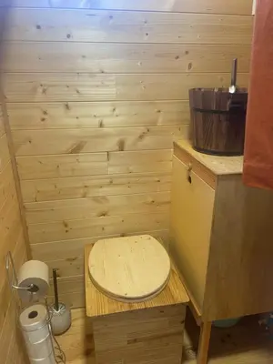 a small bathroom with a wooden toilet in a room at Tiny House en bois in Cubières-sur-Cinoble