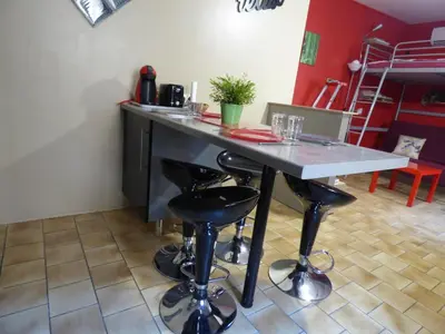 a kitchen with a table and stools in a room at Chez Odile in Sigean