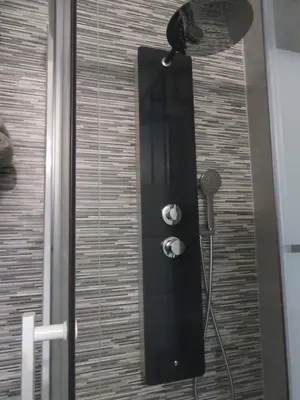 a shower with a black door with a shower head at Chez Odile in Sigean