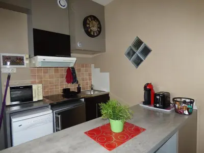 a kitchen with a counter with a clock on the wall at Chez Odile in Sigean