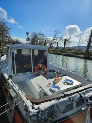 a boat on the water with a table on it at bateau tinkerbell in Labastide-dʼAnjou