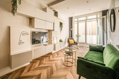 a living room with a green couch and a tv at L'Appart Central - Chic et Confort in Narbonne