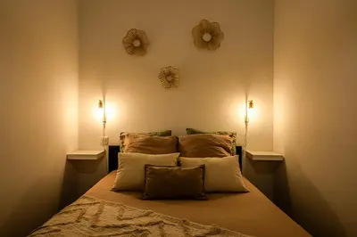 a bedroom with a bed with two mirrors on the wall at L'Appart Central - Chic et Confort in Narbonne